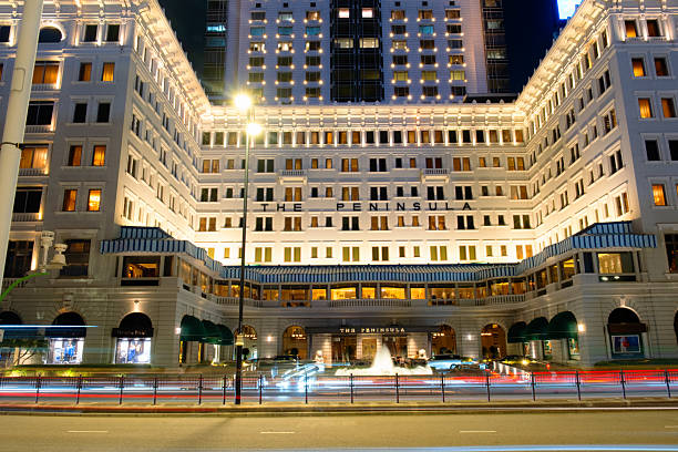 Hong Kong - August 27, 2025: Night time in Hong Kong, and this is the view looking across Salisbury Road towards the iconic Peninsula Hotel in Tsim Sha Tsui, one of five stars hotel in Hong Kong.