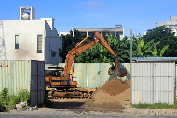 An excavator at work at a construction site, loading sand