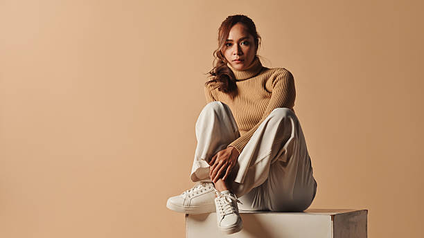 istock Confident Female Model in Cozy Knitwear on Beige Backdrop 2237088504