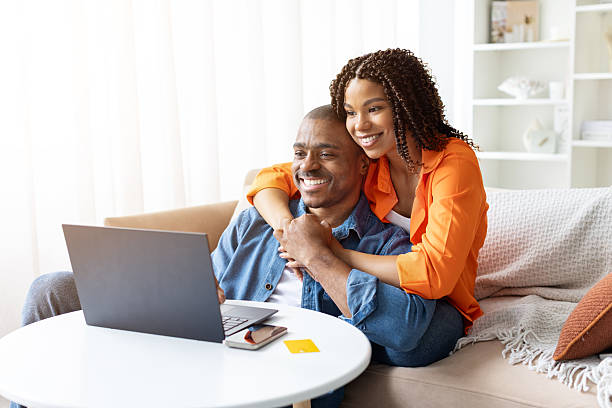 istock African American couple embracing while using laptop at home 2237089695