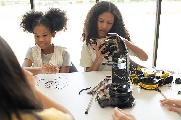 istock Focus Robotic Arm, Children Learning with Teacher in Hands-On STEM Activity.Multiracial students in robotics class with robot vehicle. 2237089816