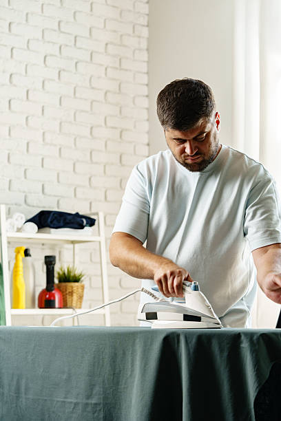 istock Man ironing clothes in a bright, modern room during the day 2237093274