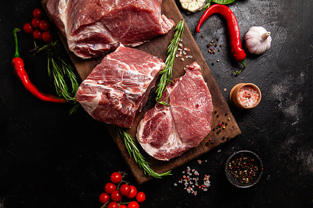 istock Raw Pork Cuts with Herbs and Spices on a Wooden Board 2237093402