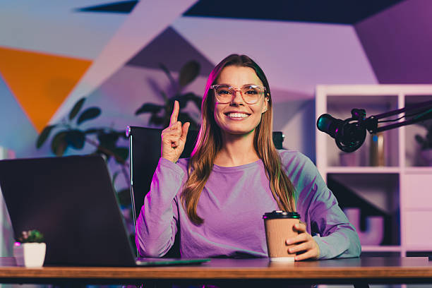 istock Young female blogger working in a modern studio environment with neon lights, discussing content creation and podcasting 2237094106