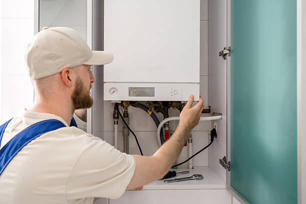 istock Repairman performs maintenance on gas boiler in modern bathroom space 2237094813