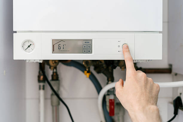 istock Repairman adjusting settings on gas boiler for optimal home heating 2237095361