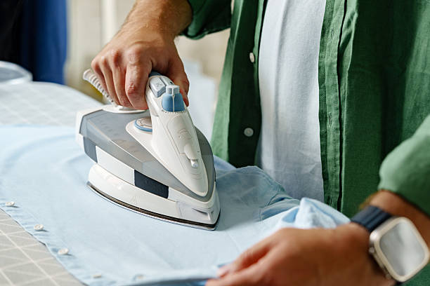 istock Ironing a blue shirt on an ironing board in a well-lit laundry room 2237095422