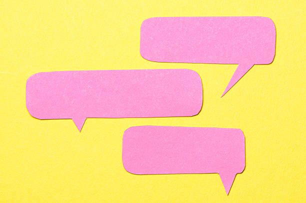 istock Pink blank cut out paper speech bubbles with copy space for text on yellow background, flat lay top view conceptual conversation backdrop 2237095501