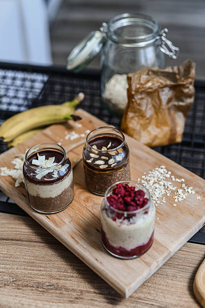 Healthy Overnight Oats Jars With Mixed Flavors Displayed On Wooden Board