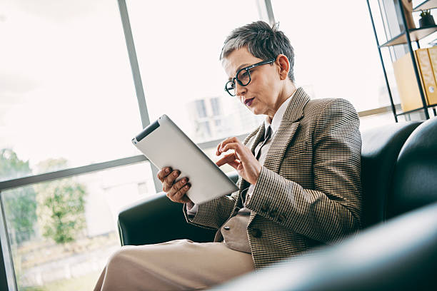 istock Confident businesswoman working attentively in a modern office setting, using a tablet for professional tasks and analysis 2237098007