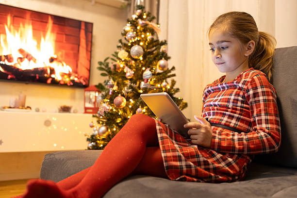 istock Girl sitting on sofa using digital tablet during christmas holidays 2237098500