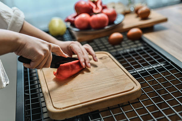 Female Chopping Red Bell Pepper Into Small Even Cubes On Cutting Board