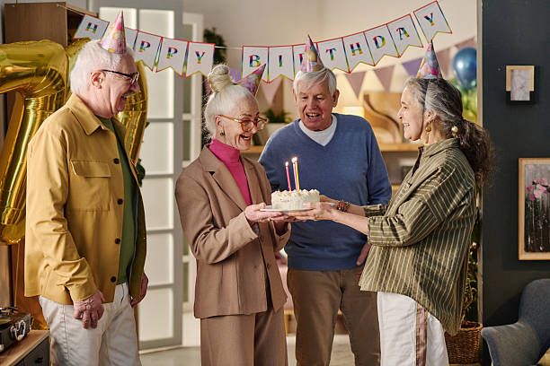 istock Senior Woman Smiling While Holding Birthday Cake with Lit Candles 2237099567