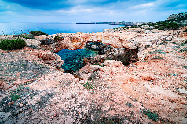 Morning at popular Crow's Arch viewpoint in Cyprus, Ayia Napa, Cape Greco. Sunrise on rocky coast Mediterranean island with the rock arch.