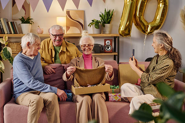 istock Senior Woman Smiling While Opening Gift Box during Birthday Celebration 2237103773