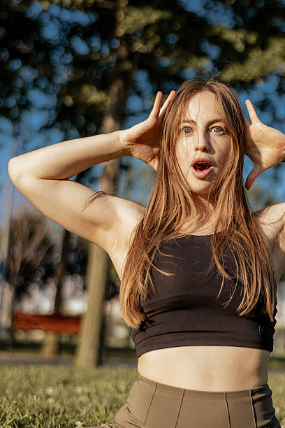 istock Beautiful blonde athlete is stretching on grass at public park. 2237104462