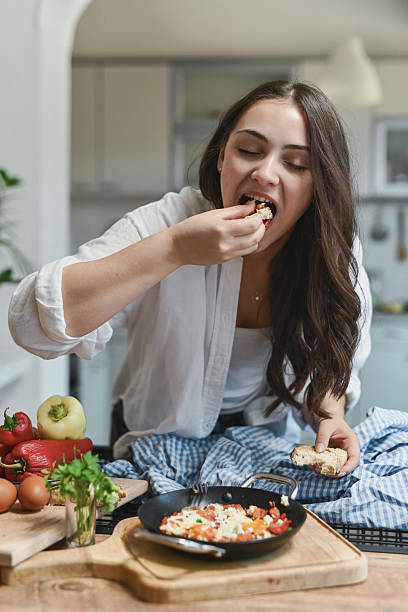 Smiling Female Savoring Flavorful Homemade Shakshouka Dish