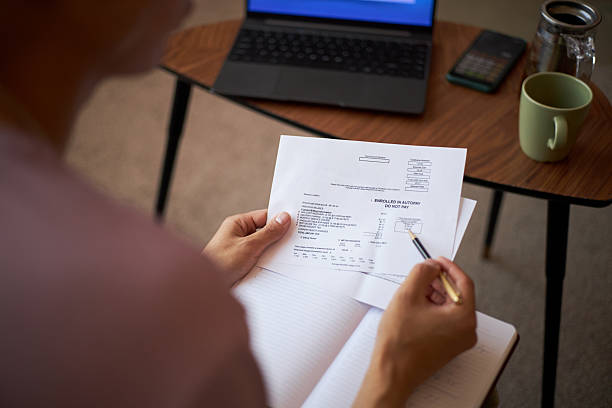 istock Young Adult Caucasian Woman Reviewing Financial Document While Taking Notes 2237106964