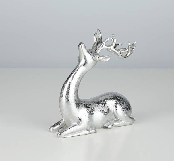 Silver metal deer sitting isolated nature background with clipping path