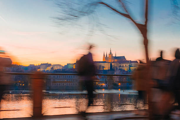As the sun sets, people stroll along the riverbank, enjoying the beautiful silhouettes and stunning views of enchanting buildings