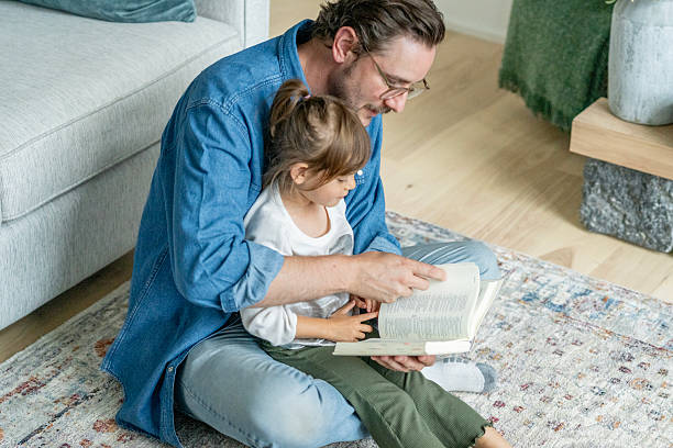 istock Father Reading With Daughter on Rug at Home, Bonding Over a Book 2237117539