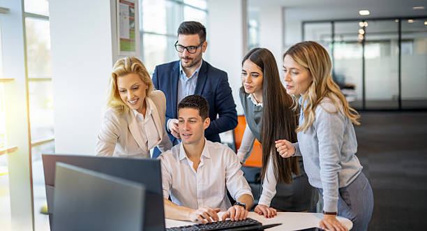 istock Business people gathered around young colleague at computer discussing potential development results and generating ideas together 2237119655
