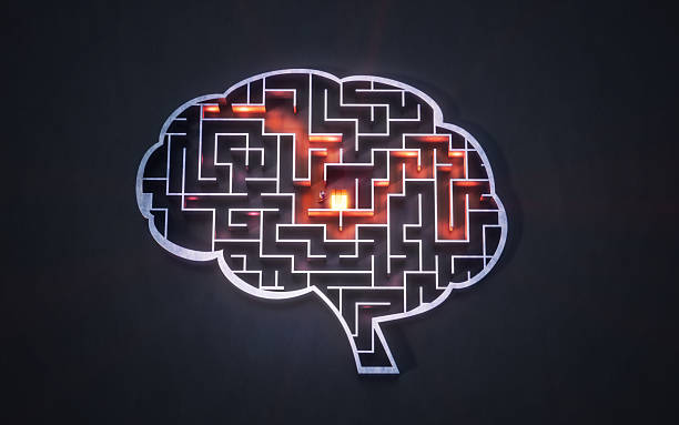 istock Businessman Seeking a Solution on a Orange-Lighted Path in a Dark Concrete Maze Shaped Like a Human Brain 2237120039