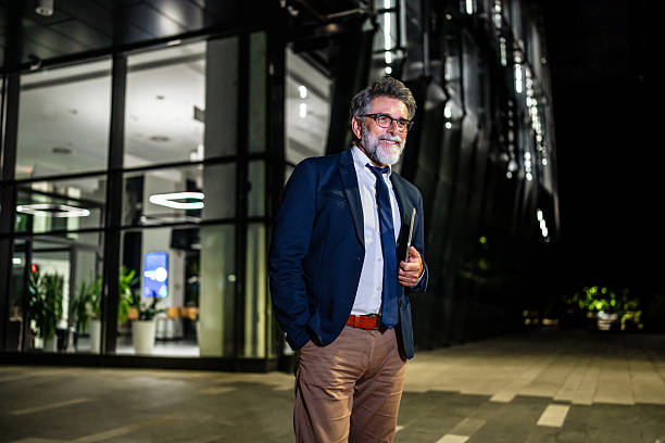 istock Mature businessman working late leaving office building at night 2237122428