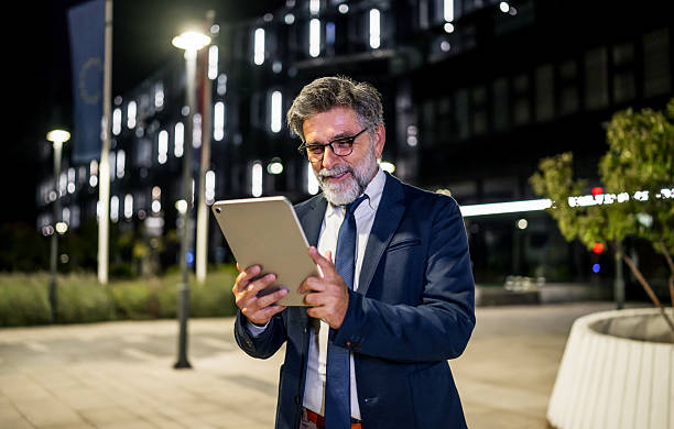 istock Mature businessman using digital tablet in urban environment at night 2237122498