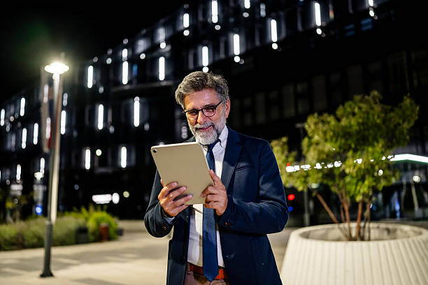 istock Mature businessman using digital tablet in urban environment at night 2237122527