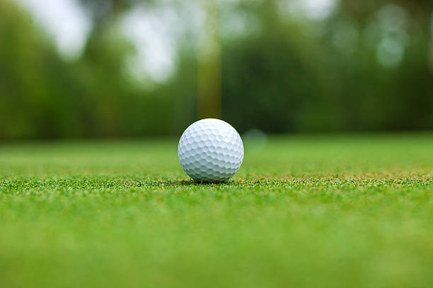 istock Low angle selective focus view of a golf ball on a green with the flag stick behind 2237123346