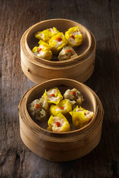 istock Steamed dumplings served in bamboo steamers on a rustic wooden table 2237126178
