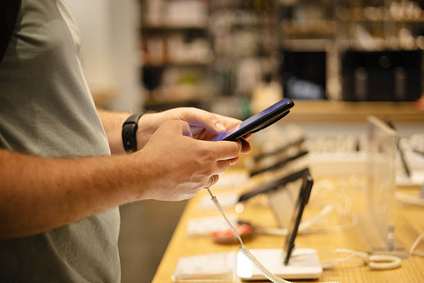 istock Closeup of man testing smartphone at electronics store showcase. 2237127736