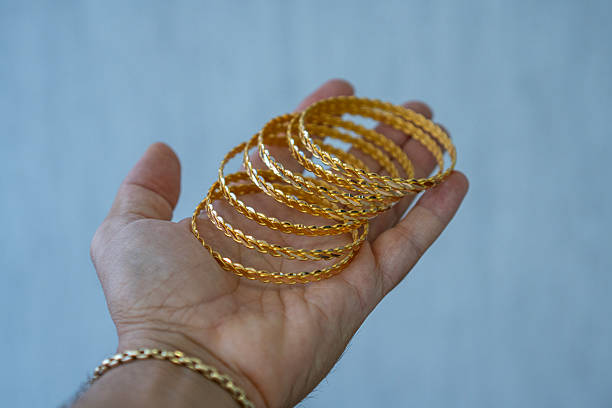 istock Hand holding golden bracelets, close up 2237134263