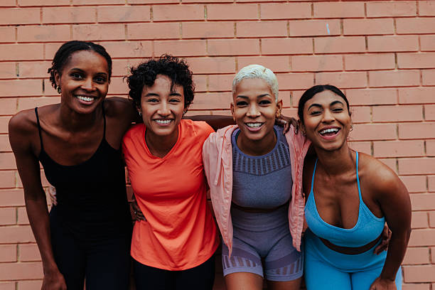 istock Four sportswomen smiling and embracing after training 2237136036