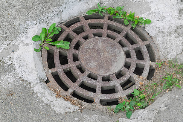 istock Rusty circular iron manhole covers on the sidewalk. 2237137189