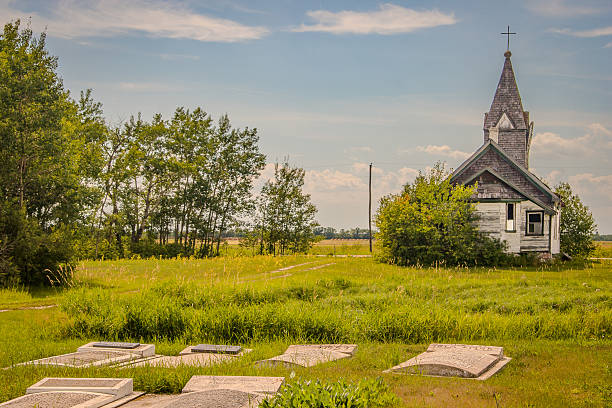 Grahamdale, Manitoba, Canada, July 22, 2006:  Quiet headstones and the historic church tell the story of generations who built their lives and faith in Bayton, Manitoba.