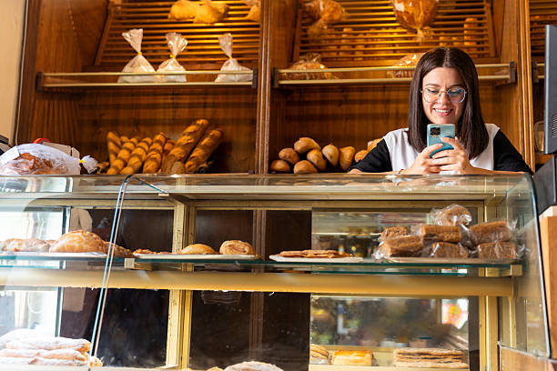 istock Woman using phone in bakery shop 2237145075