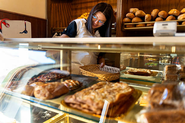 istock Woman working in a bakery bread shop serving customers 2237145130