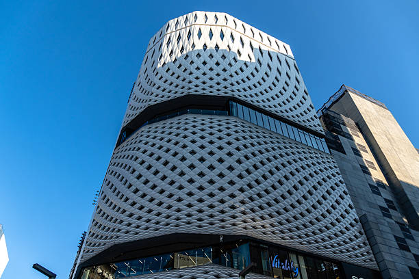 Tokyo, Japan - August 3, 2024: A striking view of a contemporary building in Tokyo's Ginza district, showcasing unique architectural design against a clear blue sky.
