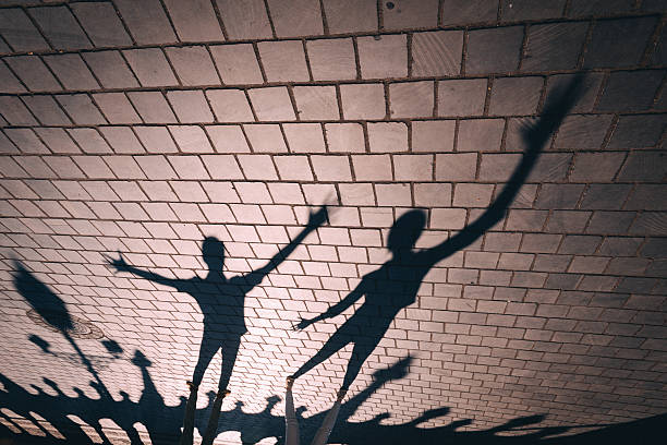istock The Shadows of Figures are cast onto the Cobblestone Surface below 2237149481