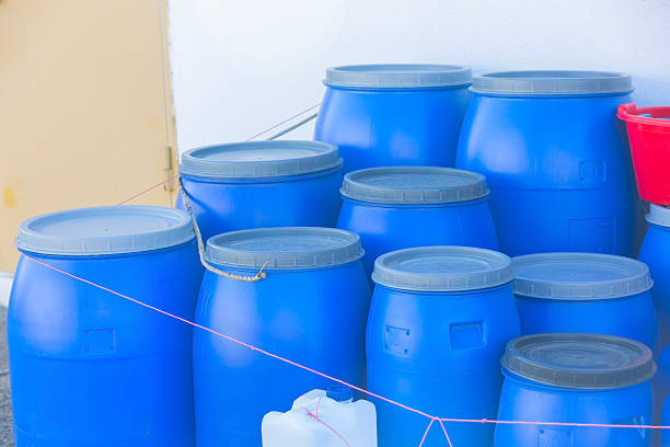 Blue plastic barrels standing together reflecting industrial storage and recycling concepts
