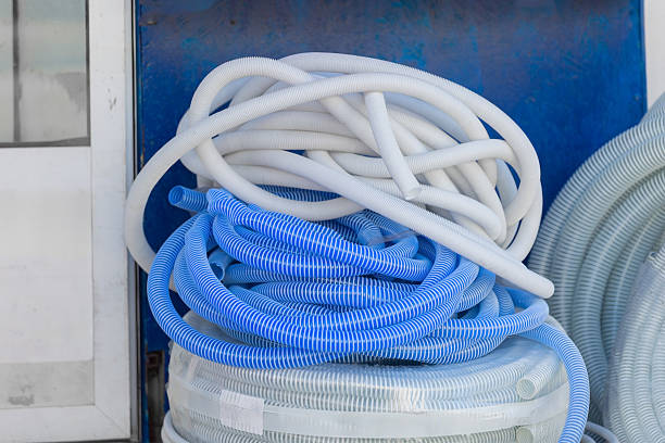 Coiled white and blue plastic corrugated hoses ready for plumbing installation
