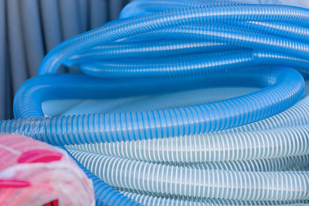 Rolls of flexible blue and white plastic corrugated hoses are ready for use