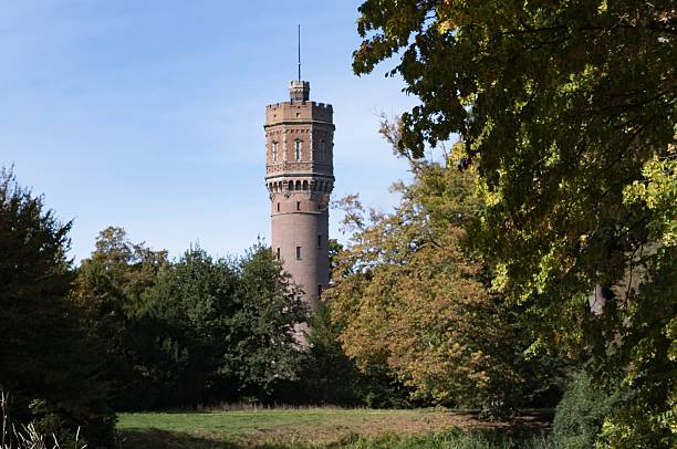 istock Historic brick water tower standing among green trees 2237154312