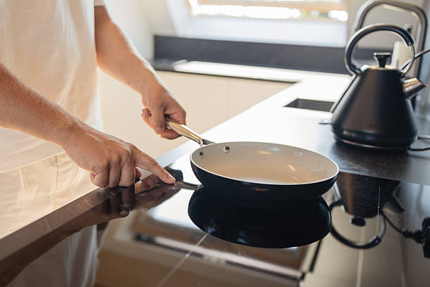 istock Man placing frying pan on modern electric stove in kitchen 2237154438