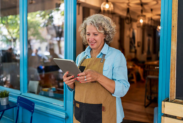 istock Smiling mature small business owner using digital tablet in coffee shop 2237156963