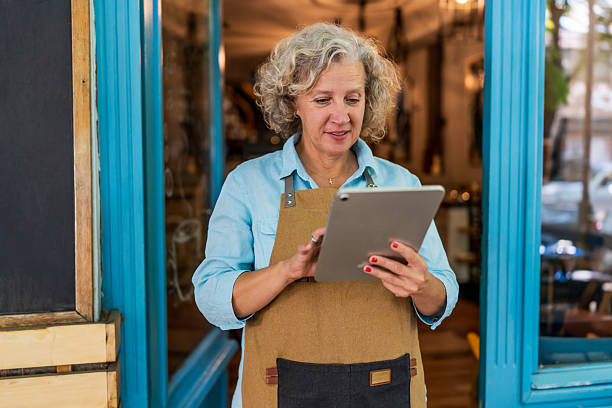 istock Smiling mature small business owner using digital tablet in coffee shop 2237157646