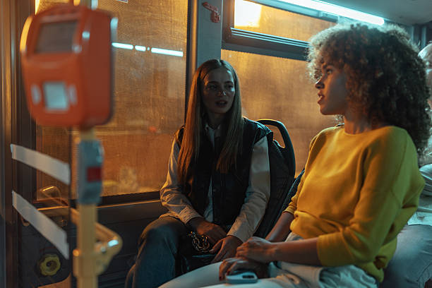 istock Two young women conversing on a bus at night 2237169884