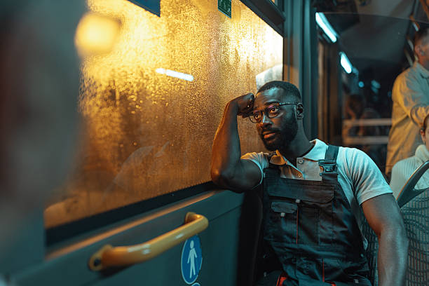 istock Pensive man in overalls on a night bus 2237169891
